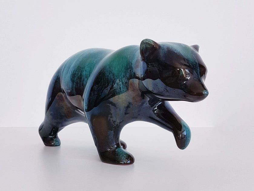 A full-view shot of an authentic Blue Mountain Pottery walking bear figurine, showcasing the iconic blue-green flow glaze.